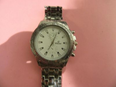 une montre posée sur une surface rose