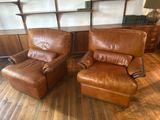 pair of leather recliners in a living room with wooden flooring