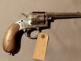 une arme à feu posée sur une table et portant une étiquette