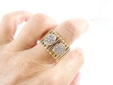 a woman ' s hand holding a gold and diamond ring