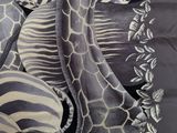 a zebra and a giraffe sitting on a bed