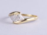 a close up of a gold ring with two diamonds on top of it