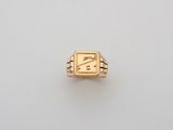 a gold ring with a house on it on a white surface