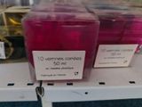 two cups of pink liquid on a shelf in a store