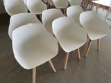 a lot of white chairs that are sitting in a room