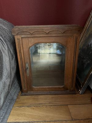 a small wooden cabinet with a mirror on top of it