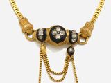 un collier en or avec des pierres noires et blanches montées sur une chaîne