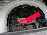 a suitcase in the trunk of a car with a red umbrella in it