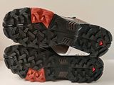 pair of black and red shoes with red soles on a white surface