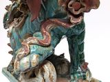 a statue of a dragon on a pedestal holding a flower