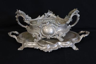 an antique silver plate with a bowl and tray on a black background