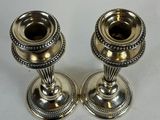 pair of silver candlesticks on a white background