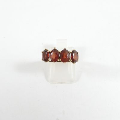 un gros plan d'une bague ornée de trois grenats