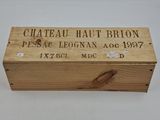 une vieille caisse en bois sur laquelle est accrochée une pancarte indiquant « Château Haut-Brion »
