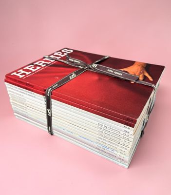 plusieurs magazines empilés les uns sur les autres sur une surface rose