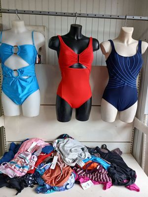 three mannequins in a room with various types of swimsuits on display