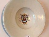 a white bowl with a coat of arms on it