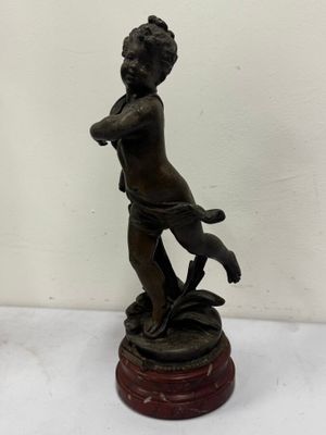 an antique bronze statue of a boy with a dog on a pedestal