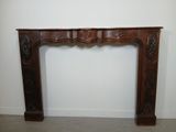 a wooden fireplace surround with carvings on the top of it