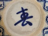 a blue and white plate with an oriental writing on it