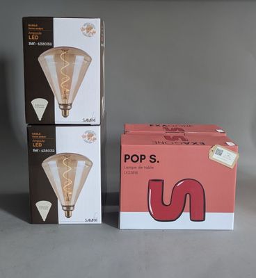 two boxes of light bulbs sitting next to each other on a table