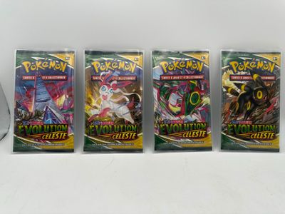 Quatre paquets de cartes à collectionner Pokémon sont alignés sur une table