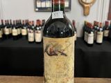 une bouteille de vin posée sur une table devant un tas de bouteilles