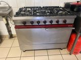 cuisinière en acier inoxydable à quatre feux dans une cuisine au sol carrelé