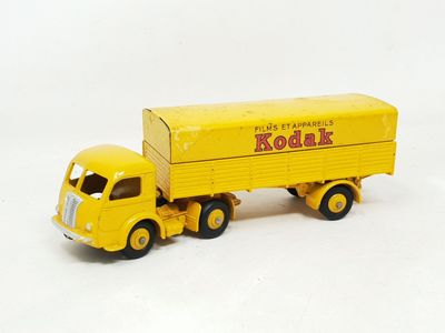 a yellow toy truck with a yellow trailer on a white surface