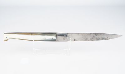 un couteau posé sur une surface blanche