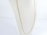 a white mannequin with a gold chain on it