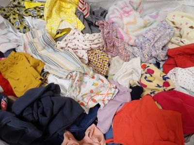 a pile of clothes that is on a bed