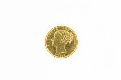 gros plan d'une pièce d'or sur une surface blanche
