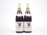 deux bouteilles de vin posées l'une à côté de l'autre sur une surface blanche