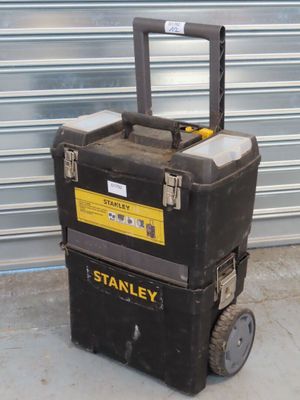 une boîte à outils noire et jaune posée sur un chariot