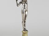 une statue en argent représentant une femme tenant une fleur à la main