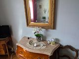 une chambre à coucher avec un lit, une commode, un miroir et une chaise