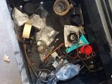a metal box filled with assorted items sitting on the ground