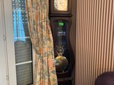 une horloge de parquet dans un coin du salon, près d'une fenêtre