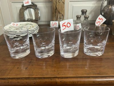 cinq verres posés sur une table, avec des étiquettes de prix dessus