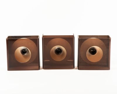three brown wooden speakers with a black and gold knob