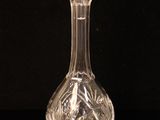 a clear glass bottle with a stopper on a black surface