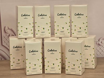 Six boîtes de catéchine sont empilées sur une table devant un mur.