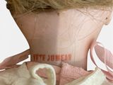 a close up of a doll ' s neck with a ribbon on it