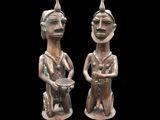pair of bronze figurines of a man and a woman holding a bowl