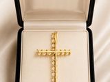 an image of a gold cross in a black box on a white cloth