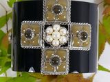 an image of a bracelet with pearls and a cross on it
