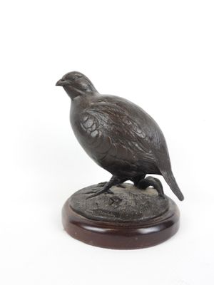 statue d'un faisan posée sur un socle en bois, sur fond blanc