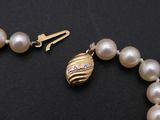 pearl necklace with a gold clasp and a white pearl bead