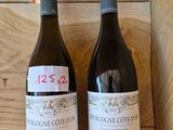 two bottles of wine that are sitting on a shelf